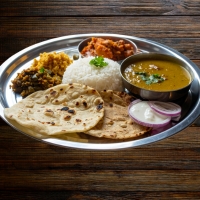 Non‑Veg Thali mit Poulet-, Lamm- und Fischcurry, Reis, Naan und Beilagen – serviert bei India4U Bern